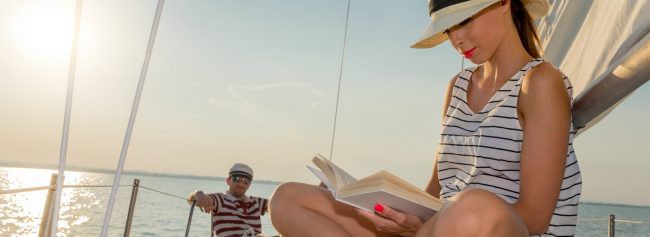 Woman with book on sailing boat Woman with book on sailing boat