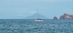 Panarea_Blick auf die Yacht an der Boje mit dem dampfenden Stromboli im Hintergrund