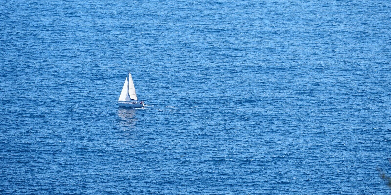 Weißes Segelboot auf blauem Mittelmeer