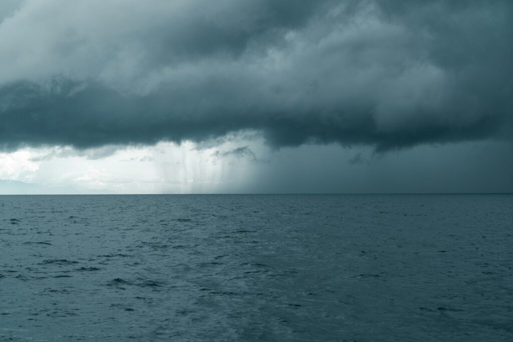 Dark cloud front with rain over the open sea