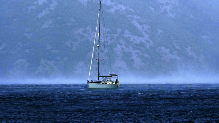 Segelyacht auf dunklem Wasser unter aufziehenden Wolken