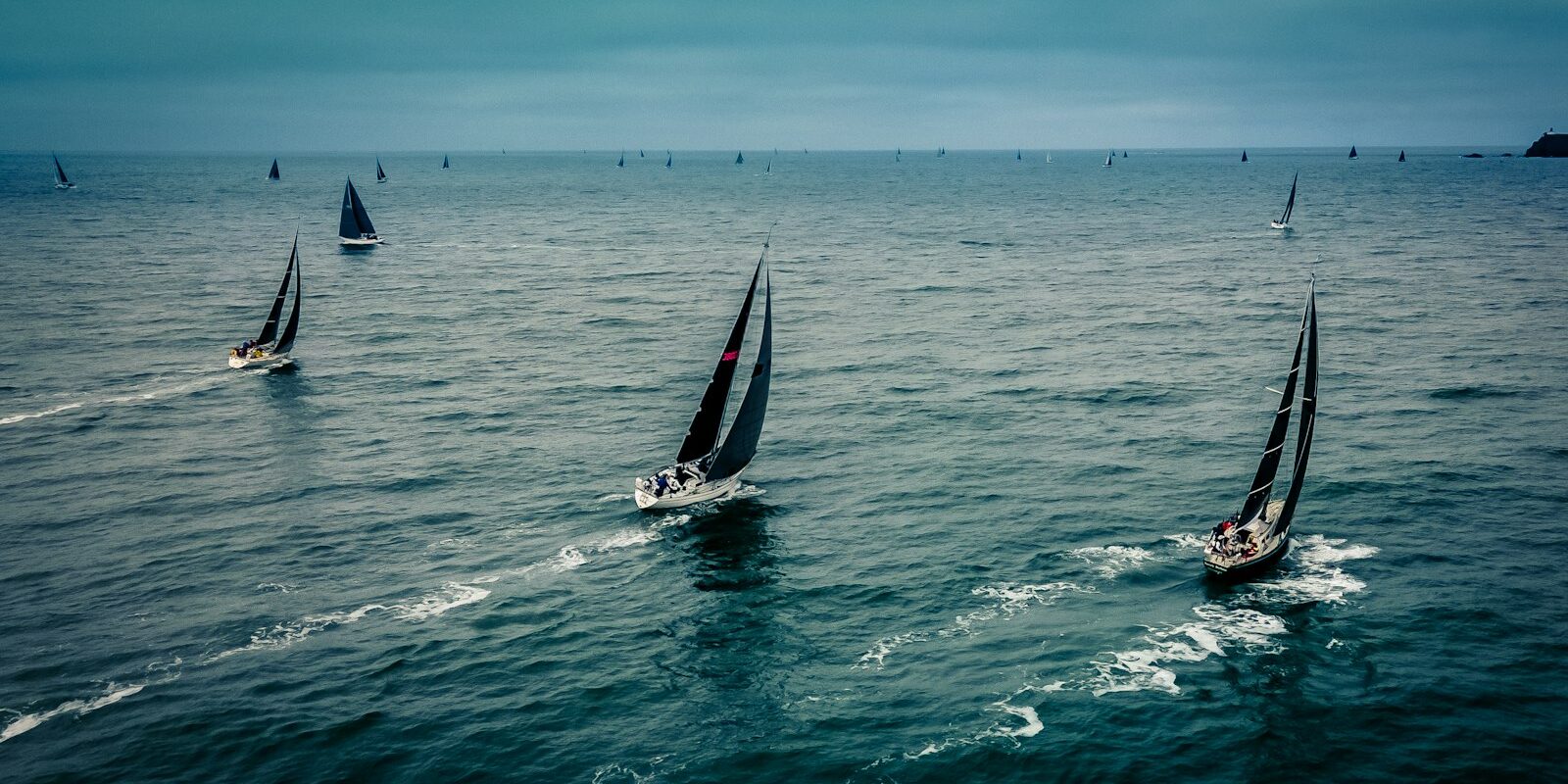 Segelboote bei einer Regatta Mehrere Segelboote bei einer Regatta auf offenem Wasser