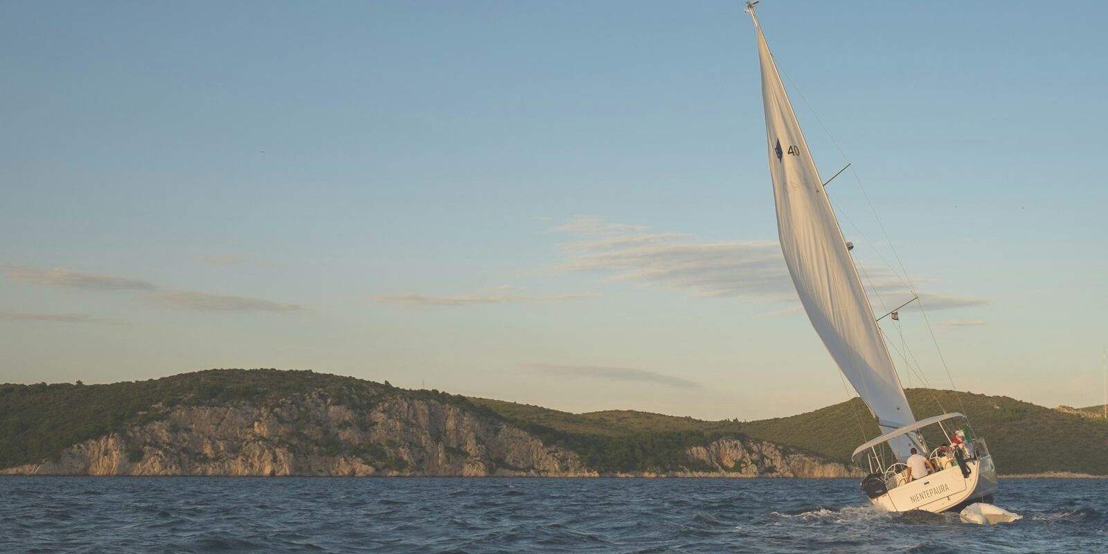 Segelyacht in Schräglage vor einer Küste Segelyacht in Schräglage vor einer Küste